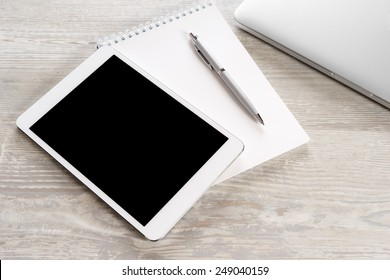 Tablet PC on a white table with a keyboard and a laptop
