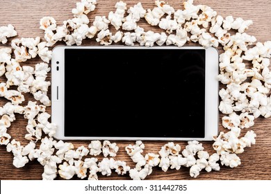 Tablet Pc On Wood With Attributes Of Cinema. Visual Metaphor For Content Consumption - Films And Media On A Mobile Device.