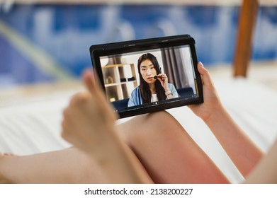 Tablet Pc Screen View. Close Up Of Unrecognizable Female, Sitting By The Blue Luxury Pool And Showing Thumb Up While Talking With Her Office Friend Colleague, Young Asian Lady In Headset