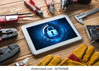 Tablet pc with security concept on screen and industrial tools around