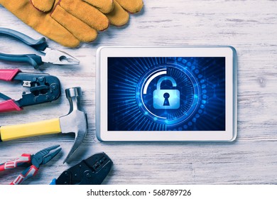 Tablet pc with security concept on screen and industrial tools around
