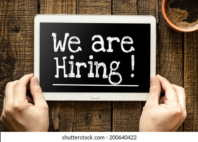 Tablet pc with text "We're hiring" which holding man