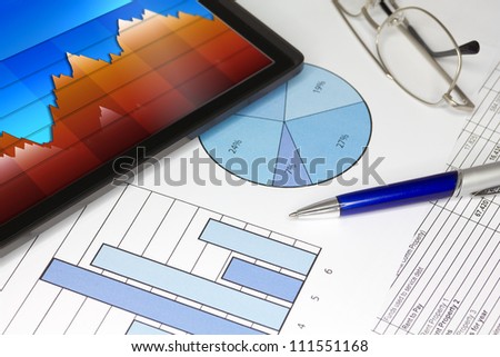 Tablet with Pen Graphs and Spreadsheet of figures
