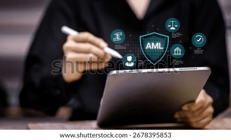 Tablet screen with AML shield icon and finance compliance symbols. Concept of anti money laundering, digital banking security, financial regulation, fraud prevention, and fintech compliance.