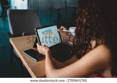 Tablet screen shows digital mind map as woman draws with stylus, representing active thinking, tech fluency, and organized freelance workflow through digital tools and focus.