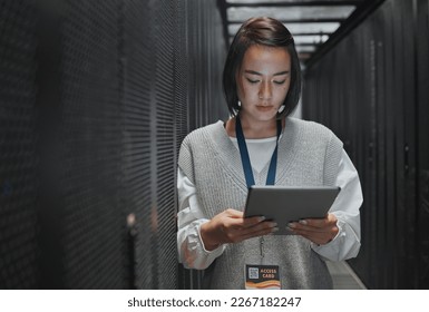 Tablet, server room and cloud computing with a programmer asian woman at work on a mainframe. Software, database and information technology with a female coder working alone on a cyber network