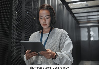 Tablet, server room and security with a programmer asian woman at work on a computer mainframe. Software, database and information technology with a female coder working alone on a cyber network