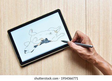 a tablet showing hand sketch the drawing of beagle dog lay down on floor with digital pens on wood table, the concept of new technology for drawing and rendering of tablet