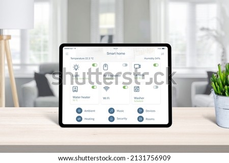 Tablet with smart home app on home desk. Concept of home automatization conrol app with frequently used devices