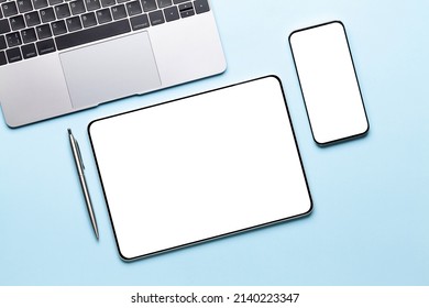 Tablet and smartphone with blank screen on desk. Top view flat lay with copy space