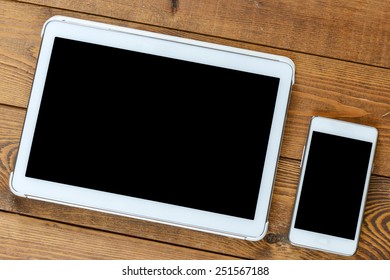 Tablet and smartphone on an old wood