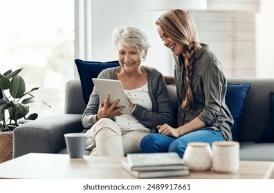 Tablet, sofa and woman relax with senior mother in home for help with online blog, internet or connectivity. Bonding, smile and elderly person learning digital technology with daughter at house - Powered by Shutterstock