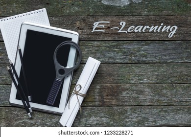 Tablet and tools for online education e-learning on wooden table background flat lay top view with copy space