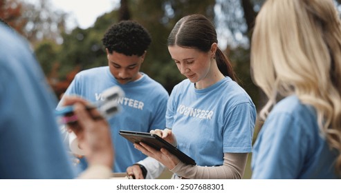 Tablet, volunteer and people in park for charity event, community service and teamwork. Volunteering, ngo group and men and women on digital tech for social media, website and online inventory - Powered by Shutterstock