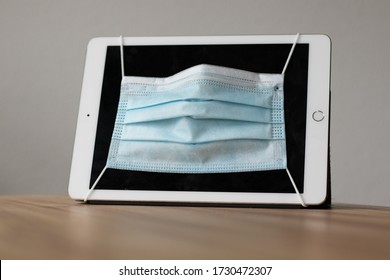 Tablet Wearing A Facial / Hygiene Mask. Cyber Security Concept. 