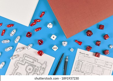 Tabletop Role Playing Flat Lay With RPG Game Dices, Hand Drawn Dungeon Map And Character Sheer, Rule Books And Pen On Blue Background