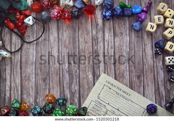 Tabletop role playing flat\
lay background with colorful RPG dices and character sheet on\
wooden desk