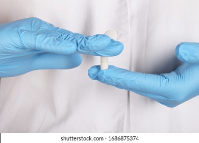 tablets in the hands of a nurse in blue rubber gloves - Shutterstock ID 1686875374
