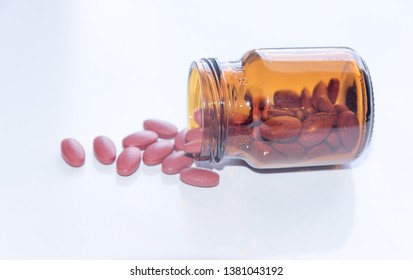 Tablets Pills Spilling Out Of Pill Bottel On White Background.