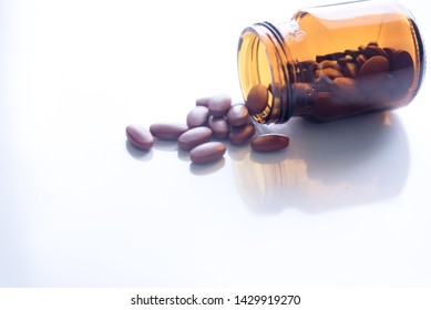 Tablets Pills Spilling Out Of Pill Bottel On White Background.