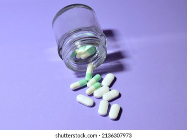 Tablets Scattered On Blue Background And In A Small Glass Container. 