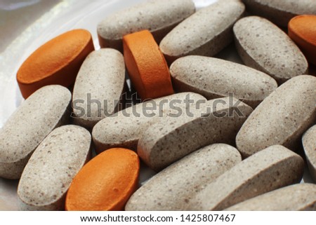 Tablets and vitamins of different colors and forms solid dosage form, useful fish oil in capsules on a bright background free space for records