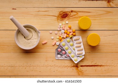 Tablets and vitamins on the table. Mortar with medicine