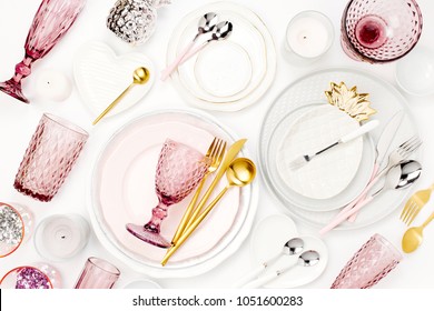 Tableware and decorations for serving a festive table.  Plates, wine glasses and cutlery with  decorative textile on white background.
