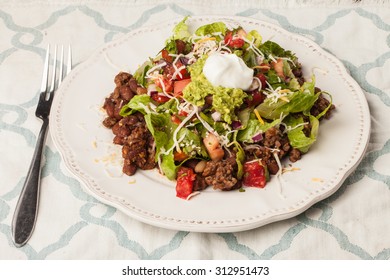 Taco Salad On An Antique Platter On A Blue And White Place Mat