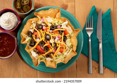 Taco Salad With Sour Cream, Salsa And Jalapeños On A Wooden Tabletop.