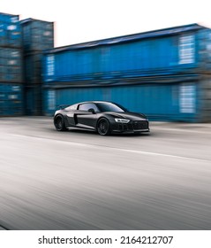 Tacoma, WA, USA
March 3, 2022
Black Audi R8 driving with blue shipping containers in the background