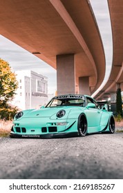 Tacoma, WA, USA
November 2, 2021
RWB Porsche 911 Parked Showing The Front Of The Car And The Drivers Side Of The Car. A Concrete Overpass Is Overhead