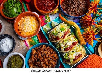 Tacos With All The Trimmings Like Chicken, Beef, Sour Cream And Cheese On A Rustic Background 