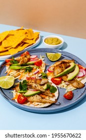 Tacos With Crispy Fish, Avocado, Guacamole Sauce, Nachos Chips And Lime. Mexican Cuisine