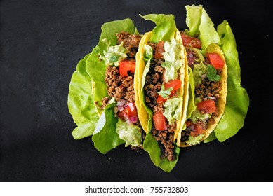 Tacos With Minced Meat Filling, Lettuce And Guacamole On A Dark Slate Background, Top View From Above, Copy Space, Selected Focus