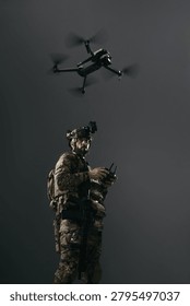 Tactical drone operator controlling UAV during covert military reconnaissance, soldier in camouflage using remote controller under flying quadcopter with dark copy space. Vertical