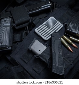 Tactical Equipment, M1911 Pistol, Knife, Ak47 Cartridges And Body Armor With The American Flag.