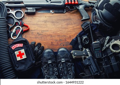 Tactical gear equipment Special forces soldier police Spec ops officer SWAT. Black military ammunition tactical gun, helmet, gloves, shotgun, pistol, accessory on Wooden background Top view copyspace