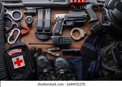 Tactical Gear Equipment Special Forces Soldier Police Spec Ops Officer SWAT. Black Military Ammunition Tactical Gun, Helmet, Gloves, Shotgun, Pistol, Accessory On Wooden Background Top View Copyspace
