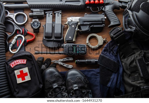 Tactical gear equipment Special forces\
soldier police Spec ops officer SWAT. Black military ammunition\
tactical gun, helmet, gloves, shotgun, pistol, accessory on Wooden\
background Top view\
copyspace\
