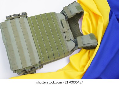Tactical, military body armor with plates on the background of the flag of Ukraine. The concept of protecting the body from shots in the war in Ukraine. - Shutterstock ID 2170036457