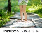 Tactile path in barefoot park created to feel the ground and other materials with bare feet. Strengthen foot and leg muscles by walking on wood, stone, gravel, sand in a park environment.