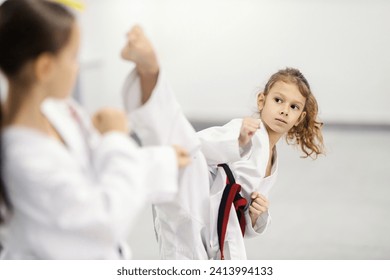 A taekwondo kid is practicing combat in martial art school.