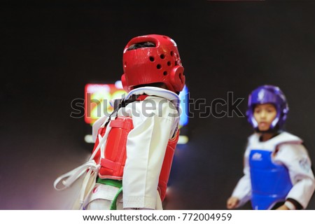 Taekwondo Kids action with uniform and green belt. Double exposure another player during the tournament taekwondo kids in stadiums.