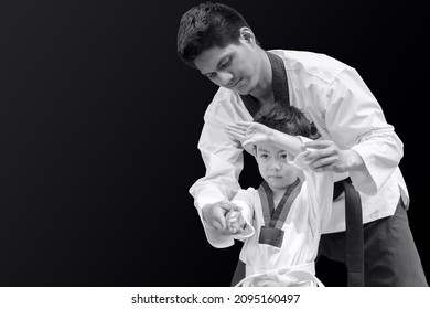 Taekwondo Master Black Belt Teaching Kid To Fight Guard On Black Background