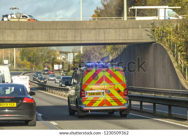 TAFFS WELL NEAR CARDIFF, WALES -\
NOVEMBER 2018: Ambulance in the fast lane of a dual carriageway at\
Taffs Well on an emergency call with blue lights\
flashing.
