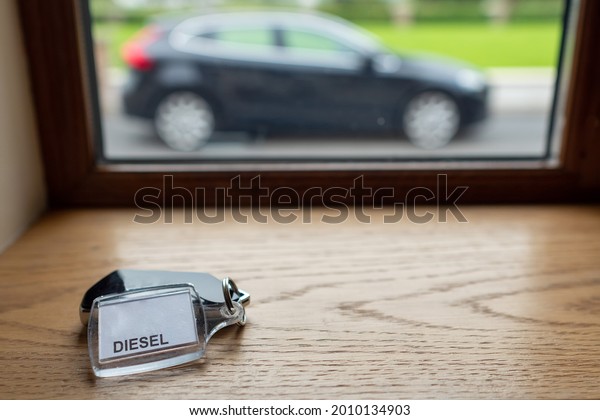 Tag with\
sign diesel on a car remote and a car out of focus in the\
background. Rented car concept and travel by\
car