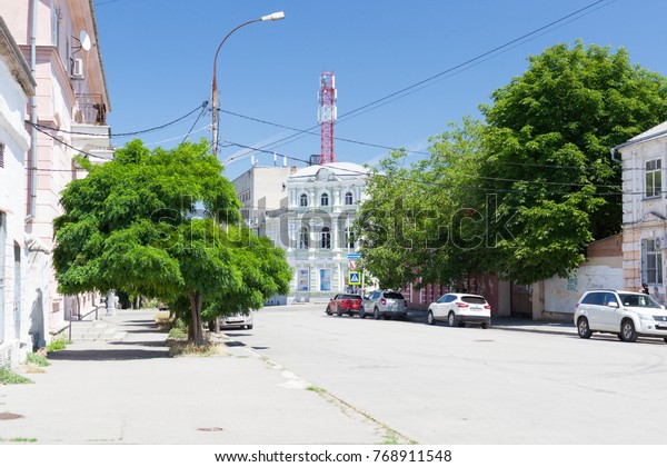 TAGANROG,\
RUSSIA - June 20, 2017: City street of Taganrog with modern cars\
and old town brick houses in the summer   \
