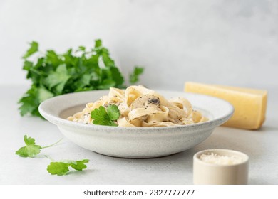 Tagliatelle pasta with mushroom chicken and cream sauce. Alfredo pasta in bowl on light background close-up view - Powered by Shutterstock