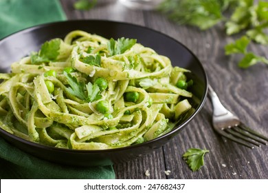 Tagliatelle pasta with spinach and green pea pesto, selective focus - Powered by Shutterstock